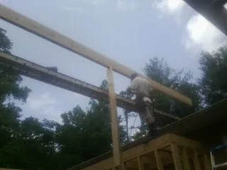 Carpenter setting a ridge beam over a new addition frame — Ice Dam Removal by Roofing Brothers in Pine Mountain Valley