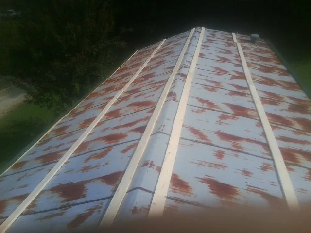 Rusted metal roof panels with new wood purlins before replacement — Storm Damage Roof Repair in Pine Mountain Valley by Roofing Brothers