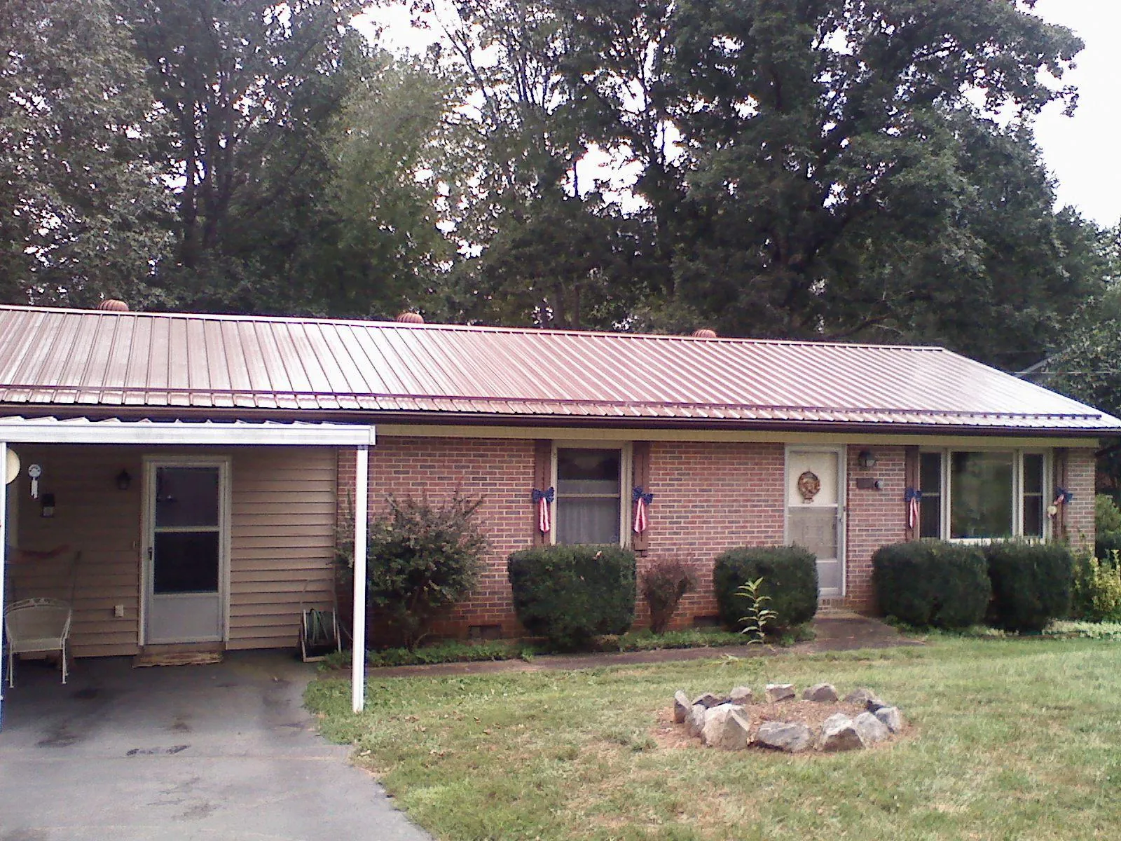 Bronze metal roof and carport on a brick ranch home — Roof Repair work by our crew in Pine Mountain Valley